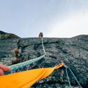 Capture the thrill of rock climbing with this dynamic low-angle shot showcasing determination and teamwork.